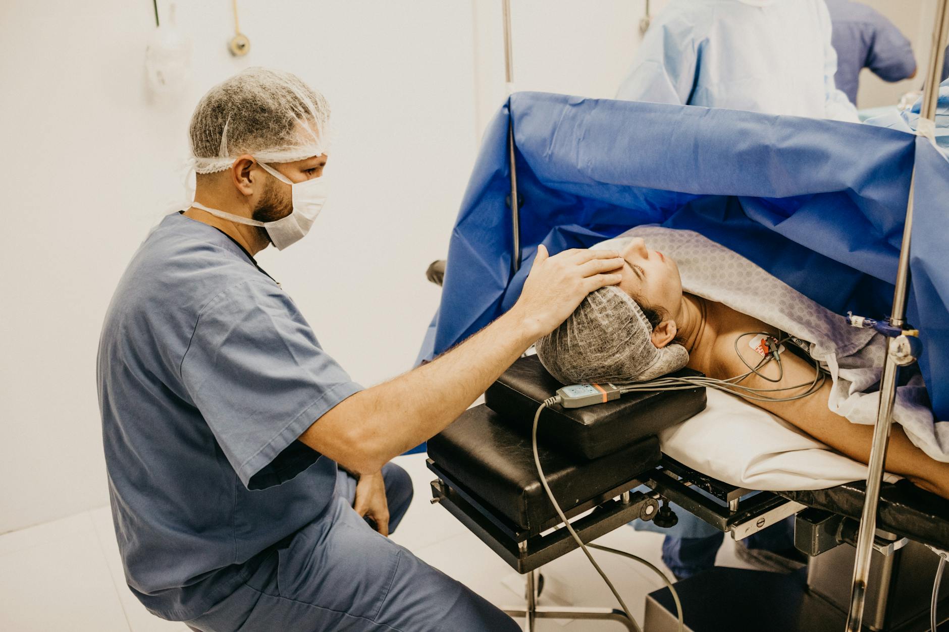 Surgeon offering comfort to a patient about to undergo surgery in a hospital operating room.